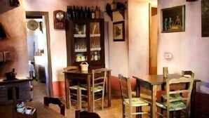 A dining area with wooden furniture, a clock, and a wine rack. - Typical home country quaint with antique furniture (cineto romano)