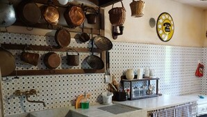 A kitchen with a marble countertop, hanging pots, and a tiled backsplash. - Typical home country quaint with antique furniture (cineto romano)