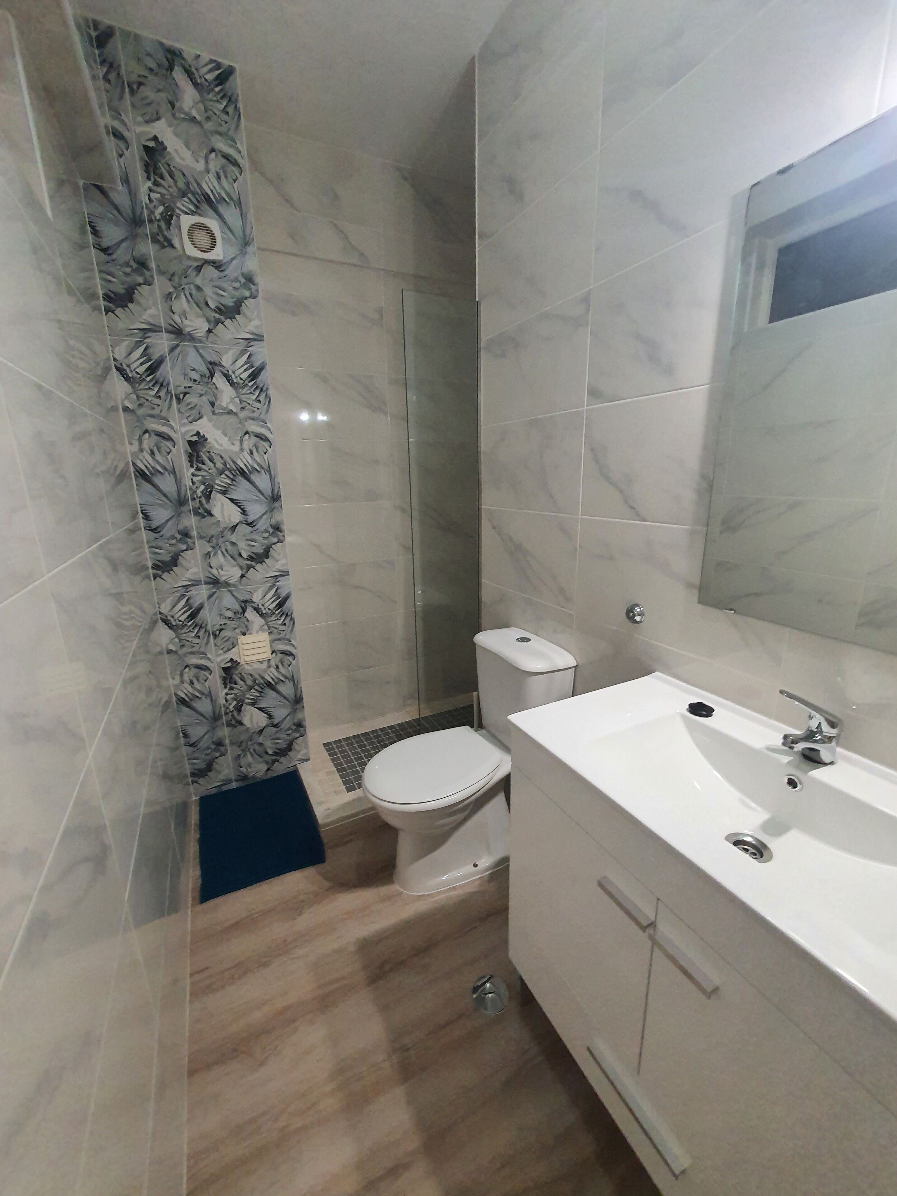 Een badkamer met toilet, wastafel en douche.
