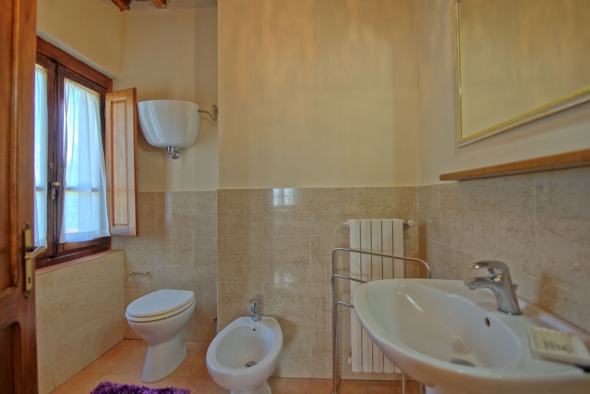 Un baño con inodoro, bidé y lavamanos.