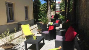 An outdoor seating area with wicker furniture and potted plants. - Beautiful T3 "design", 4 *, quiet in the garden, town center -2 bedrooms, 2/5 people (Lourdes)
