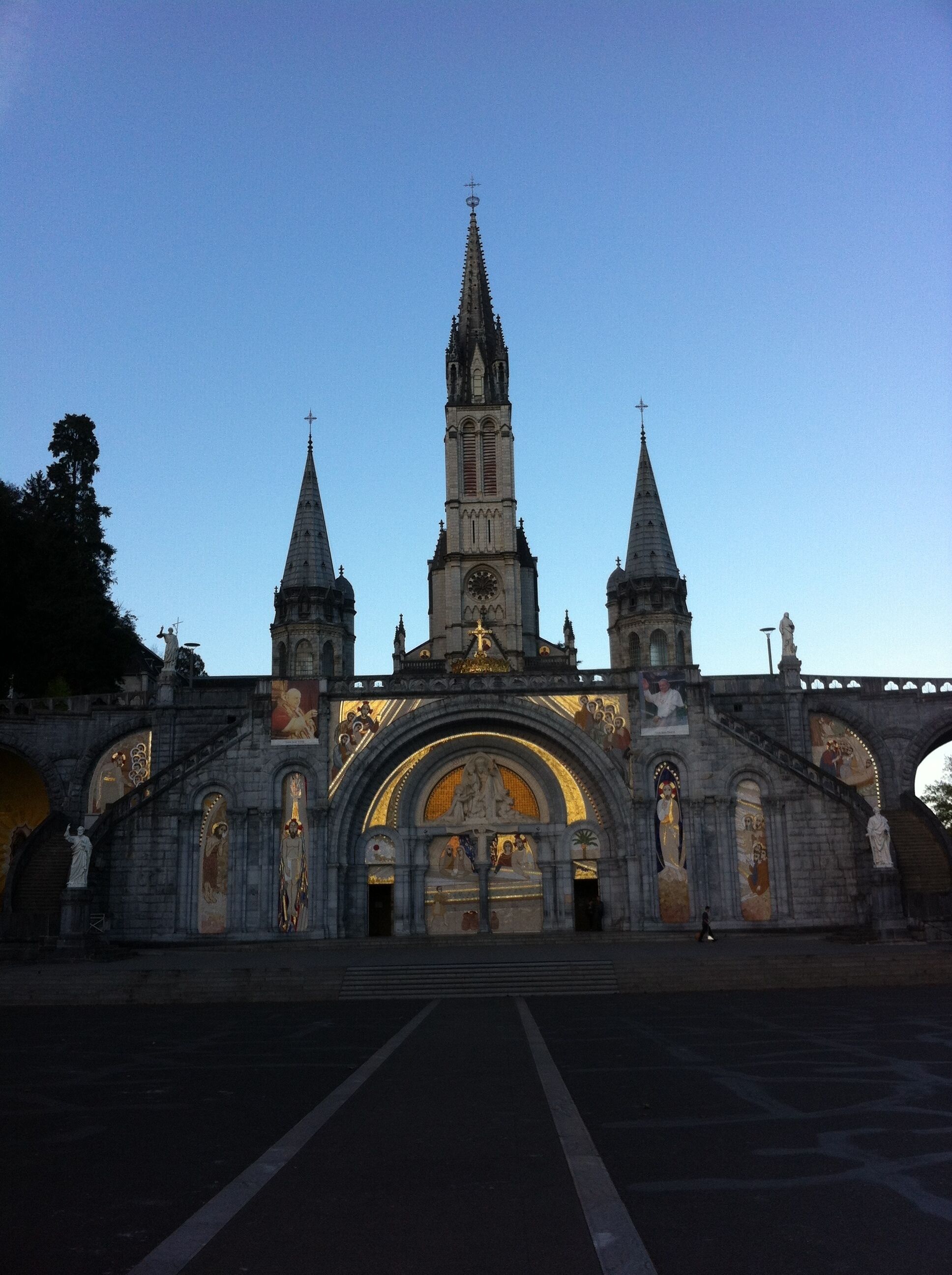 Eine historische Kirche mit einer zentralen Kuppel und zwei Türmen, verziert mit aufwendigen Steinmetzarbeiten und Statuen.