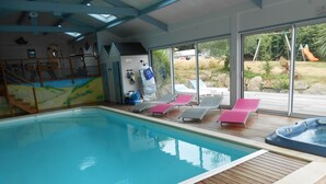 An indoor swimming pool with wooden decking, lounge chairs, and a hot tub. - Villa With Pool Indoor heated to 28 °, Jaccuzzi, Sauna (Lannion)
