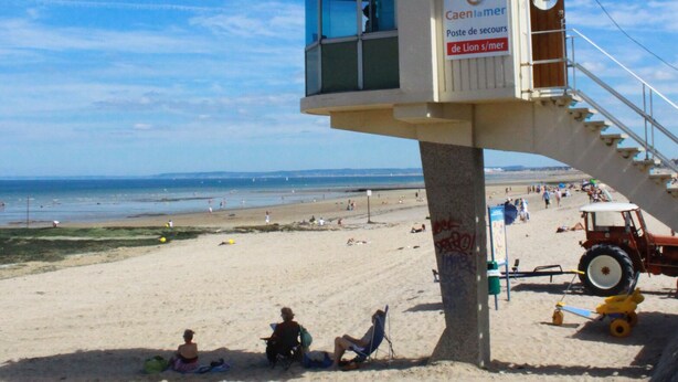 Une tour de surveillance avec un toit bleu et une pancarte indiquant qu’il s’agit d’un poste de sauveteurs.