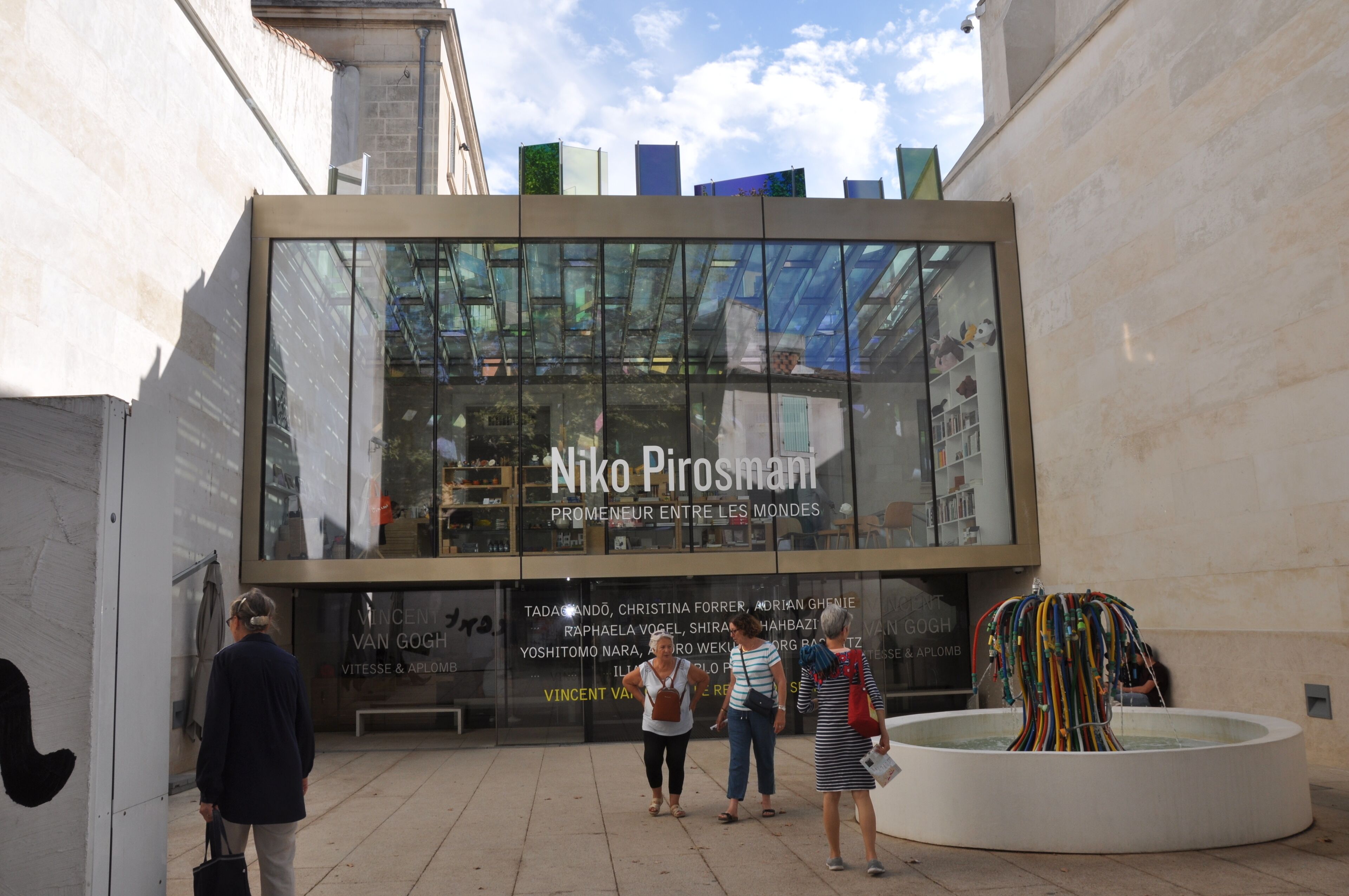 Un edificio moderno con facciata in vetro e la scritta 'Niko Pirosmani' ben visibile.