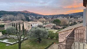 Un quartier résidentiel avec des maisons, un jardin et une vue sur une ville au loin.