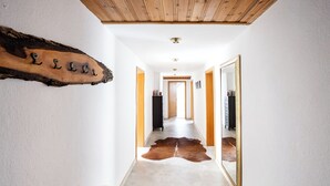 A hallway with a wooden ceiling, a cowhide rug, and a wooden sign with letters. - Country Living in the southern Eifel, vacation apartment in the Sauertal N° 2 (Ralingen)