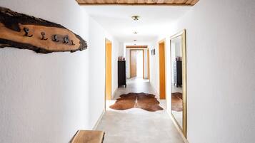 Ein Flur mit Holzboden, einem Cowhide-Teppich und einem Holzschild mit Buchstaben.