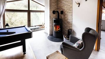 Ein modernes Wohnzimmer mit Billardtisch, Kamin und gemütlicher Sitzecke.