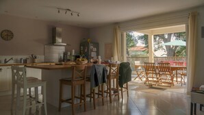 A kitchen with a dining area, a clock on the wall, and a view of the outside.