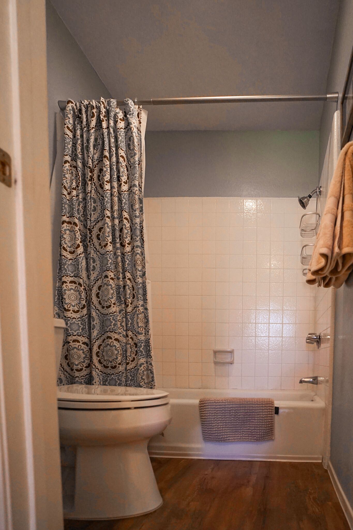 Un baño con inodoro, bañera y cortina de ducha.