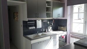 Una cocina moderna con un lavamanos, encimera y ventana.
