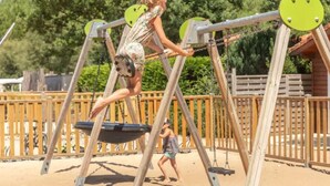 Ein Spielplatz mit Schaukeln und einer Rutsche.
