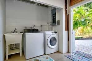 A compact laundry area with a washing machine, a dryer, and a sink.