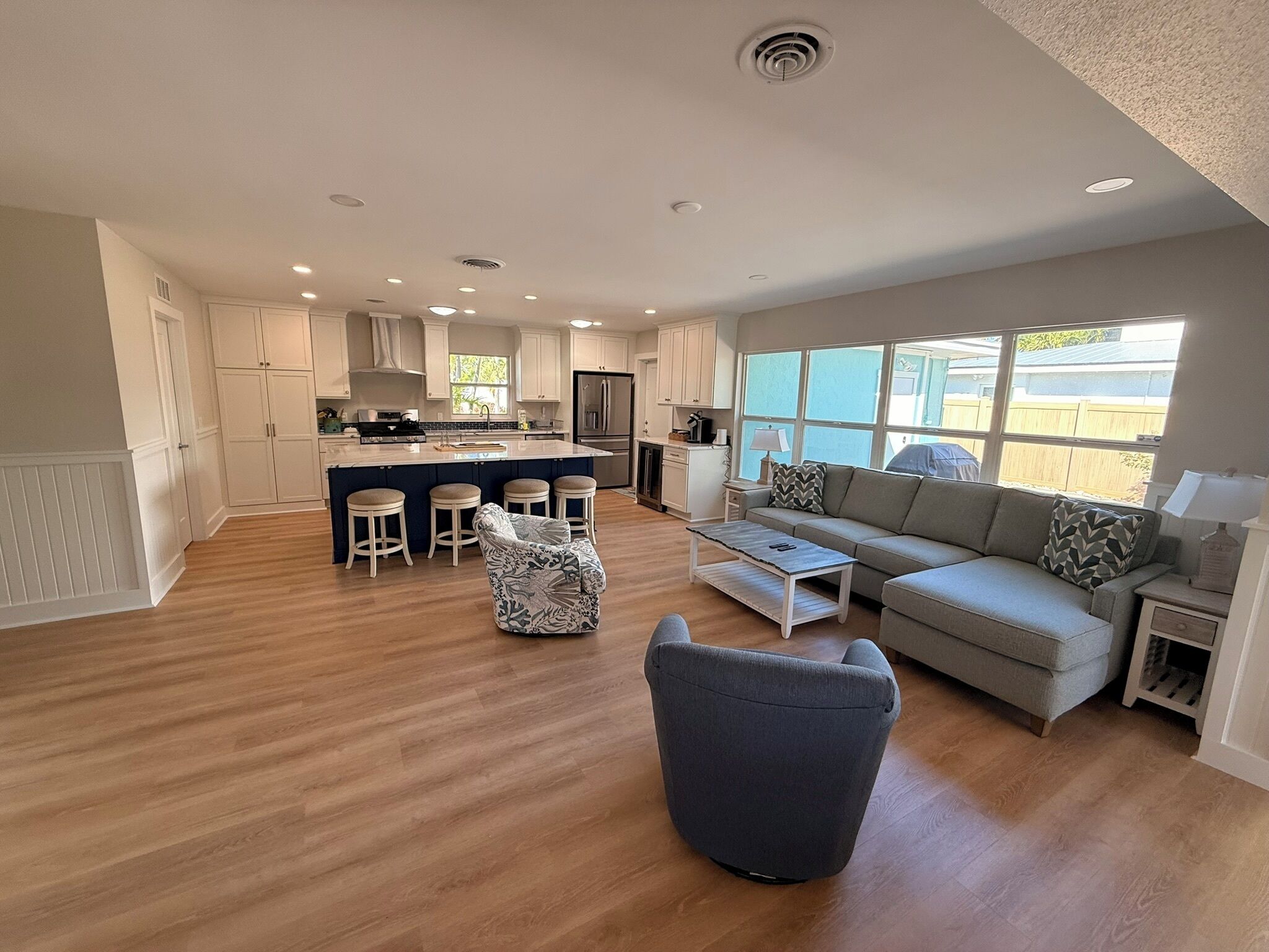 A spacious living area with a sofa, a coffee table, and a patterned ottoman.