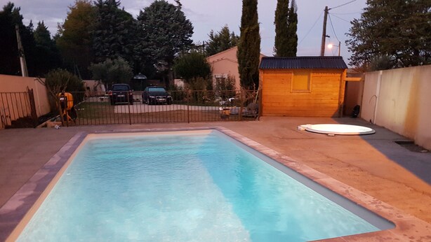 Ein rechteckiger Pool mit einer gefliesten Kante, umgeben von Sand.