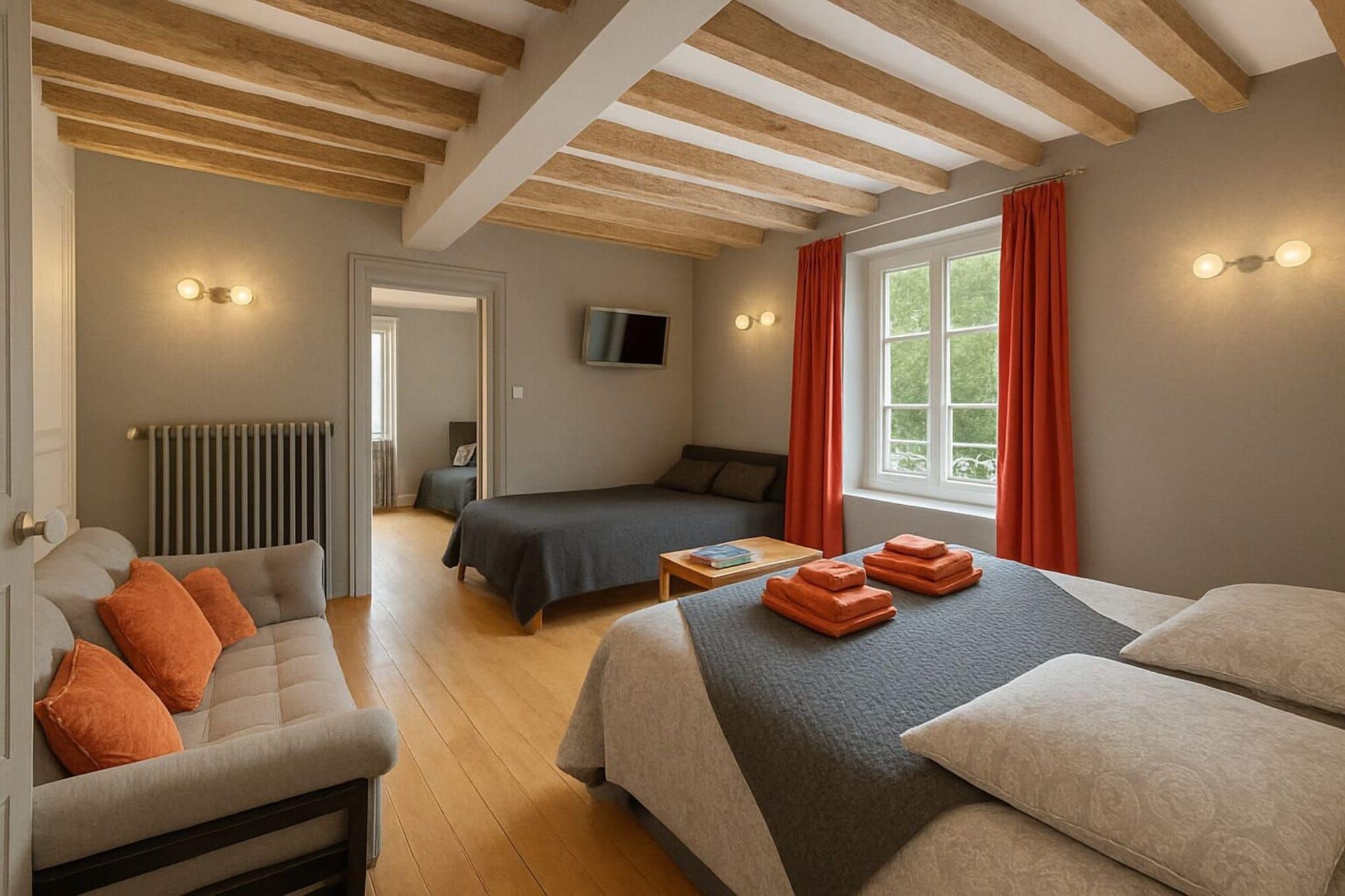 A bedroom with a large bed, a sofa, a TV, and a window with curtains.