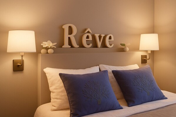 Une chambre à coucher avec un lit, deux lampes fixées au mur et un panneau décoratif au-dessus du lit.