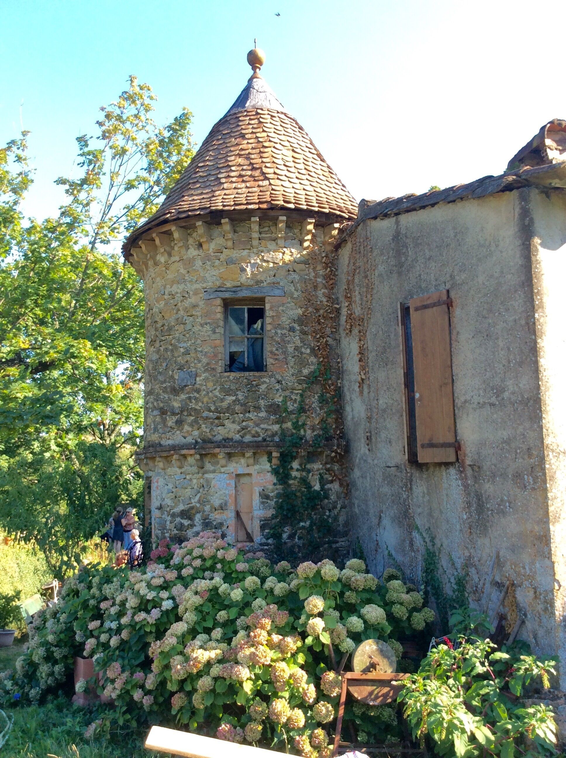 Ein Steinhaus mit einem spitzen Dach und einem kleinen Fenster.