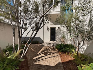 Stroll through lush gardens to the entrance of this welcoming property.