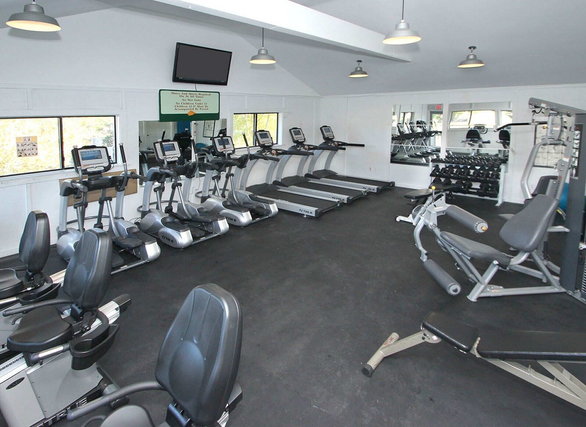 A gym with treadmills, elliptical machines, and weightlifting equipment.