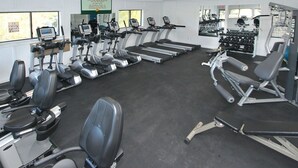 Ein Fitnessstudio mit Laufbändern, Crosstrainern und Gewichten.