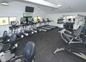 A gym with treadmills, elliptical machines, and weightlifting equipment.