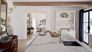 A spacious kitchen with a marble countertop, a sink, and a dining area with a table and chairs. - Gorgeous in Gordes, Elegantly Furnished with Pool, Tennis and Views  (Gordes)