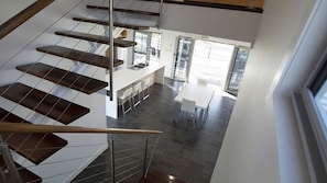 Ein modernes Interieur mit einer Treppe, einer Küchenzeile und einem Essbereich.