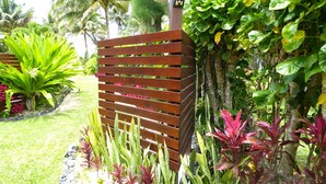 A wooden fence with a vertical post and a small electronic device on top. - Great Value steps from Muri Beach with Kayaks, Paddle Boards, Pool, Free WIFI ! (Muri Beach)
