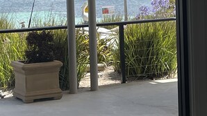 A balcony with a view of the sea, a potted plant, and a sign. - SeaChange Sceale Bay (Sceale Bay)