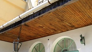 Un edificio con un balcone, un soffitto in legno e una torre con balcone.