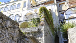 Una scala in pietra conduce a un edificio con portali ad arco e balconi.