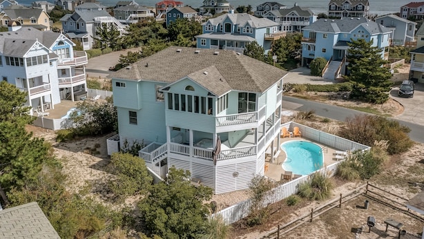 Une maison à deux étages avec un balcon et une piscine.