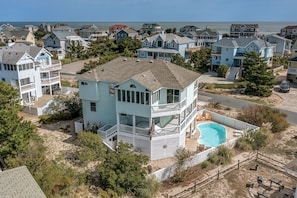 A two-story house with a balcony and a swimming pool.