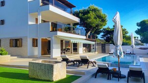 A modern two-story house with a swimming pool, outdoor seating, and a covered patio area. - Charming  Villa, quiet location, stunning view and infinity pool is all you need (Ražanj)