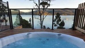 Ein Whirlpool mit Blick auf einen See und Berge.
