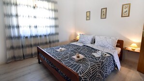 A bedroom with a bed, two bedside lamps, a window with curtains, and three framed pictures on the wall. - Apartment Umag-Savudrija, air conditioning, washing machine, WiFi, garden terrace (Savudrija)