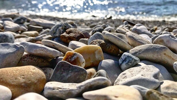 A pebbled beach with a pier in the background. - Apartment Umag-Savudrija, air conditioning, washing machine, WiFi, garden terrace (Savudrija)