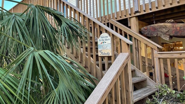 A wooden staircase leading to a building with a sign reading 'Welcome to the Shore.'