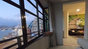 En balkong med utsikt över stadsbilden och en matplats med en soffa och ett bord.