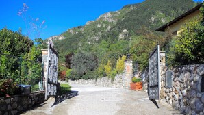 Un camino de piedra que conduce a una casa con montañas al fondo.