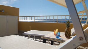 A balcony with a table, chairs, and a pineapple. - attic with stunning views (Alghero)