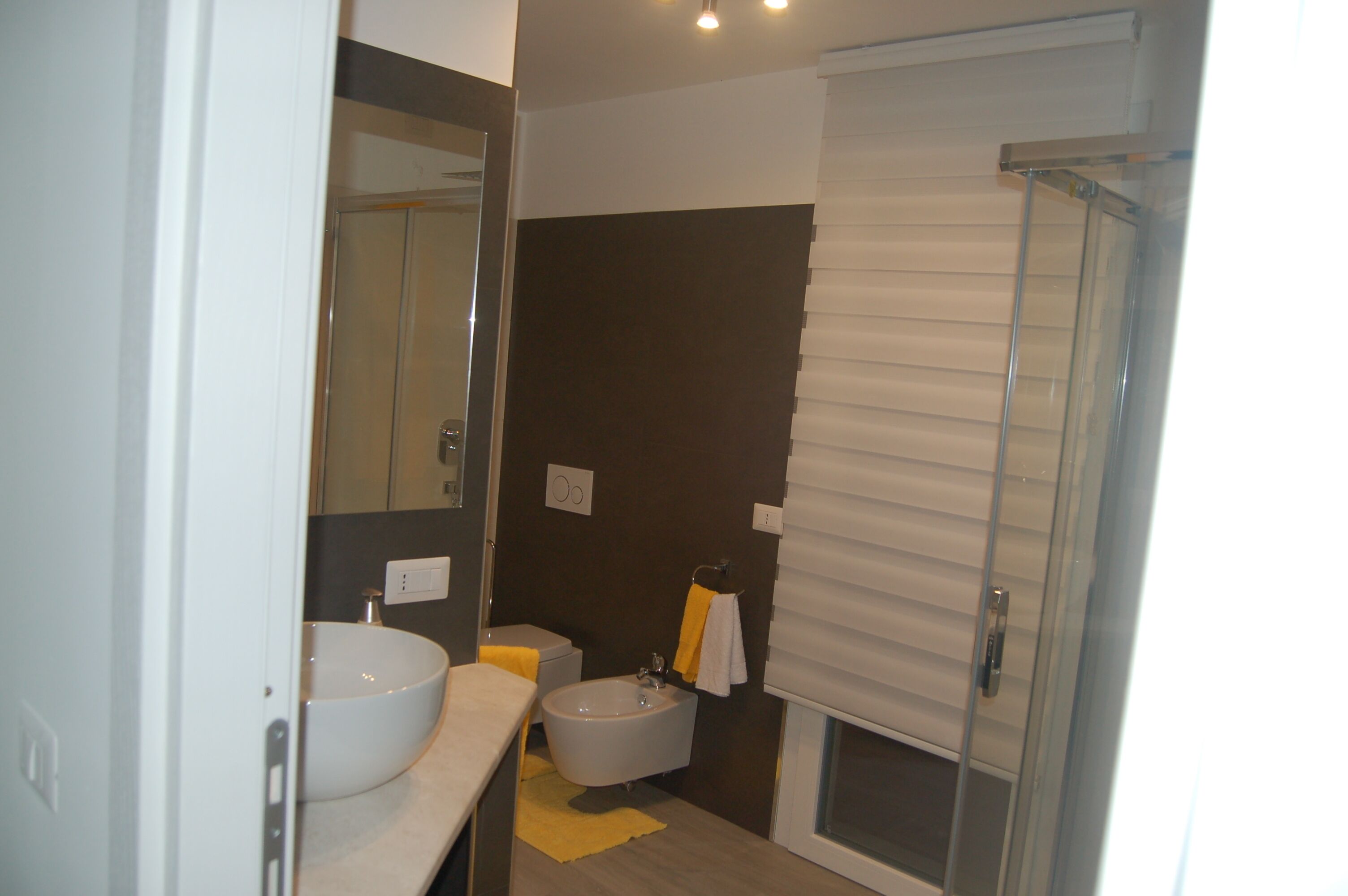 Une salle de bain moderne avec un grand miroir, un lavabo blanc, une baignoire et un espace douche.