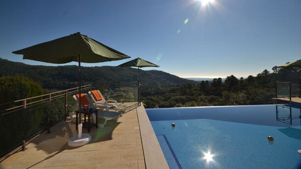 A rooftop infinity pool with a clear view of the surrounding landscape, including hills and trees. - Awesome Coastal Views, Infinity Pool & BBQ area, Very Private Family Villa  (Monchique)