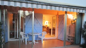 Een huis met een glazen toegangsdeur die uitkomt op een eetruimte met een tafel en stoelen.