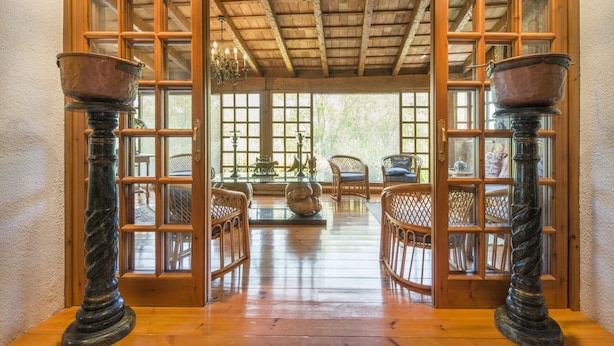 Interior de madera con puerta de vidrio que da a un patio.
