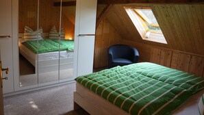 Une chambre à coucher avec un lit, une chaise et une armoire avec un miroir.