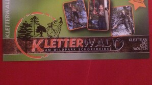 Une couverture de livre intitulée « Kletterwald », avec une illustration représentant une forêt et un loup, ainsi que trois photographies de personnes en train d’escalader.