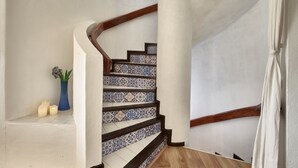 Una scala con piastrelle decorate e corrimani in legno.